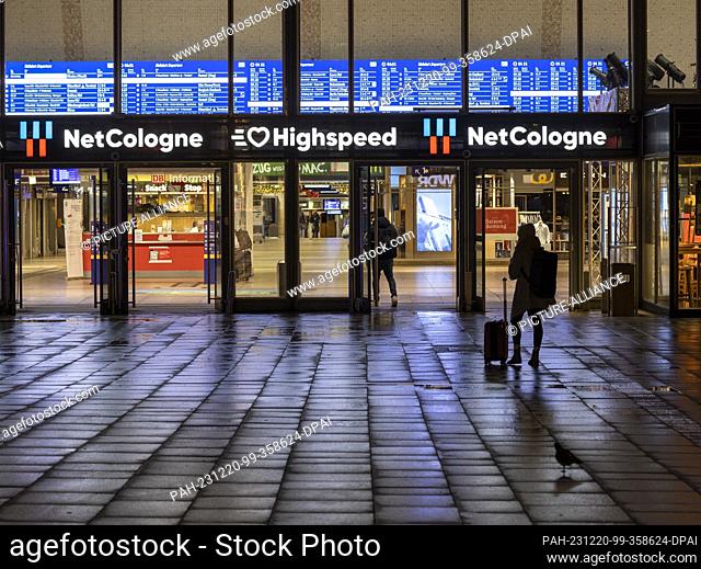 20 December 2023, North Rhine-Westphalia, Cologne: A passenger stands in front of Cologne Central Station. In a ballot that ended on Tuesday