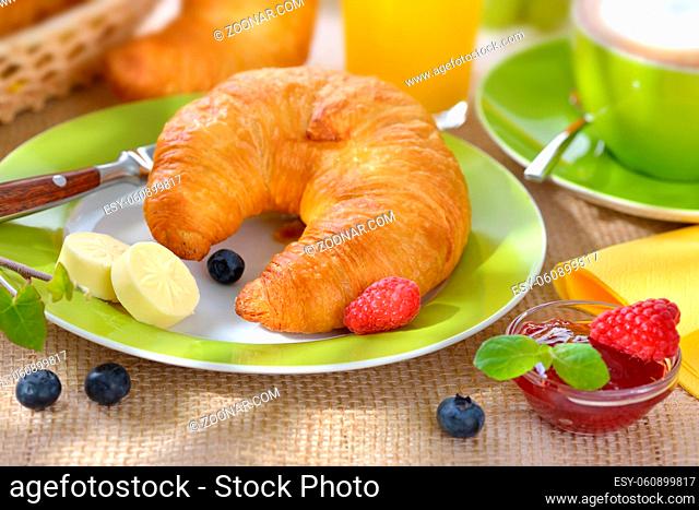 Bunter Frühstückstisch mit Croissants und Cappuccino - Breakfast table with a cup of cappuccino and fresh croissants