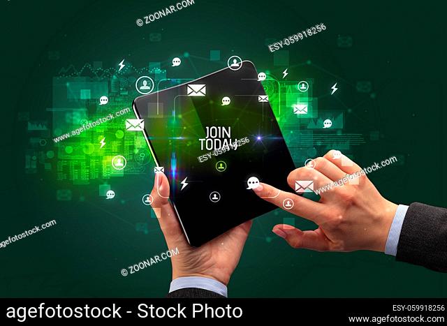 Businessman holding a foldable smartphone with JOIN TODAY inscription, social networking concept