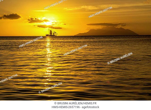 Seychelles, Mahe Island, Beau Vallon, sunset on Silhouette island and a sailboat, from Beau Vallon beach
