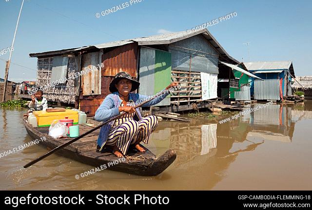 Siem Reap, Cambodia - January 22, 2011: Mother and son on a boat in a floating village