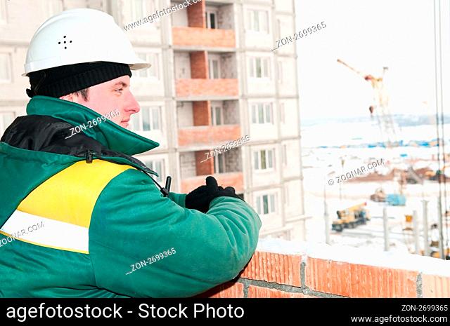 one builder foreman at construction site in winter work wear and hard hat