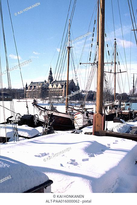 Sweden, Stockholm, boats in foreground, church in distance, under snow