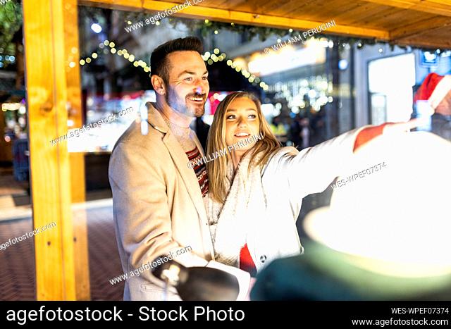 Happy man and woman shopping at Christmas market