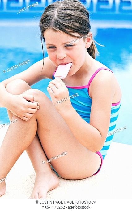 Shot of a Cute Blonde Girl On Holiday by the Pool  Eating an Ice Lolly