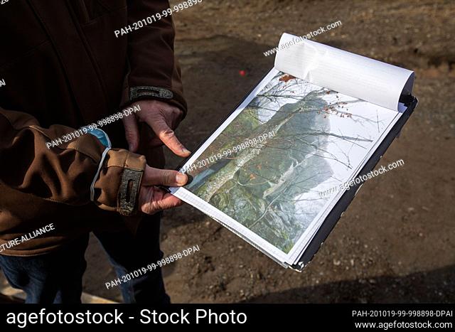 19 October 2020, Baden-Wuerttemberg, Todtnau: Klaus Merz, head of the building authority of the town of Todtnau, holds a clipboard with a photo of a rock which
