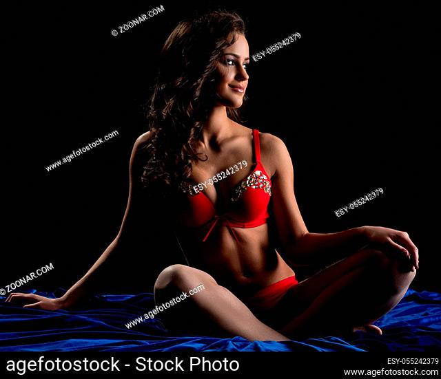 Image of pretty underwear model posing while sitting in bed