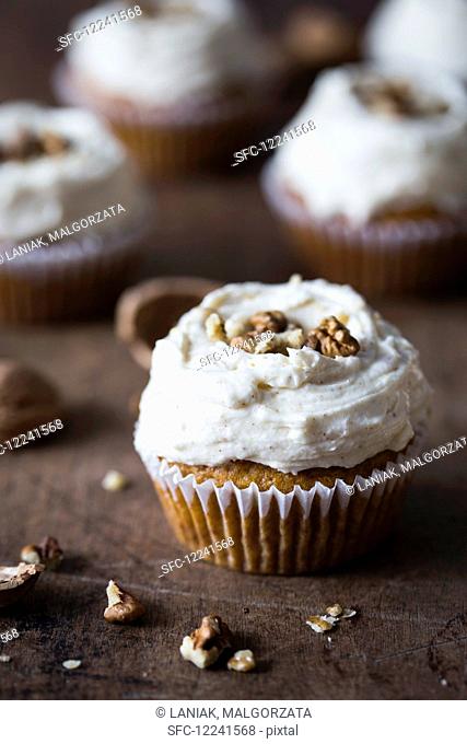 Pumpkin cupcake with cream cheese frosting and walnuts