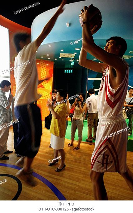 A young visitor playing with the Yaoming web sculpture at wax museum, Shanghai, China