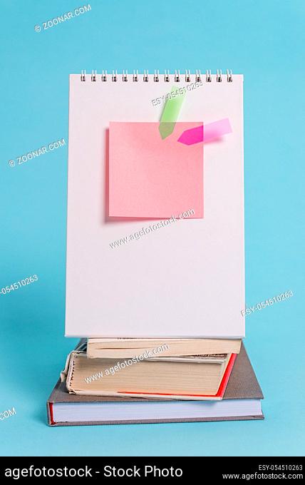 Spiral notebook sticky note arrow banners stacked books pastel background