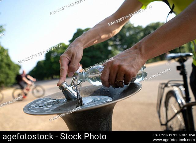 19 July 2022, Great Britain, London: A man fills up his water bottle at a drinking fountain in Kensington Gardens park. In the London region