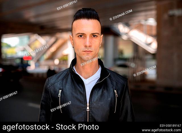 Portrait of handsome young confident Italian man with undercut