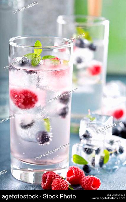 Sparkling water with berry and mint ice cubes