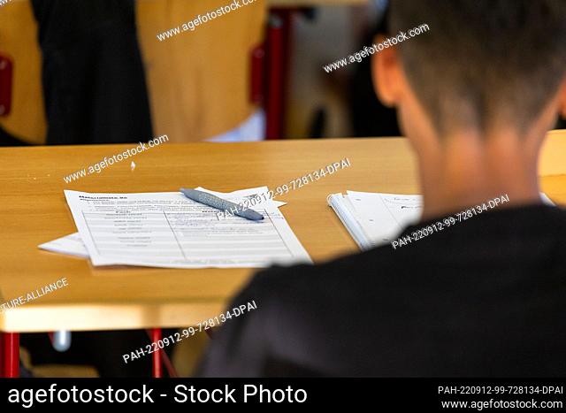 12 September 2022, Baden-Wuerttemberg, Heitersheim: A pencil and worksheets lie in front of a student. Students in Baden-Württemberg are back in school today...