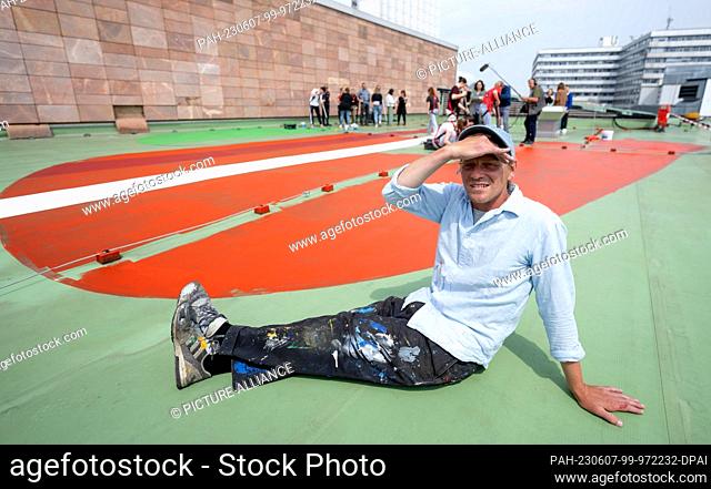07 June 2023, Saxony, Chemnitz: Belgian artist Larsen Bervoets sits on the roof of the Stadthalle in Chemnitz in the midst of work for his artwork