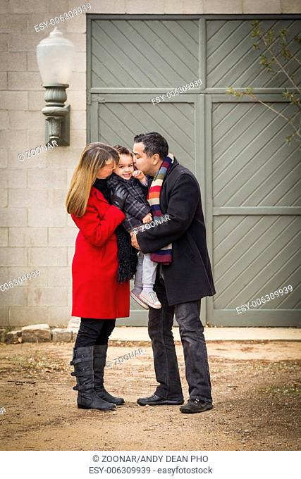 Warmly Dressed Family Loving Son in Front of Rustic Building
