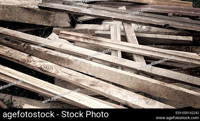 Old boards, sticks, slats piled up in a heap after repair of the premises. Intended for disposal or reuse