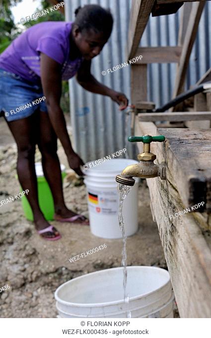 Haiti, Petit Goave, Woman getting clean water from treatment plant