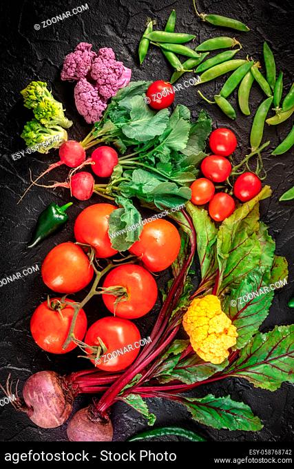 Summer salad ingredients. Raw vegetables, shot from above on a dark background. Vegan groceries