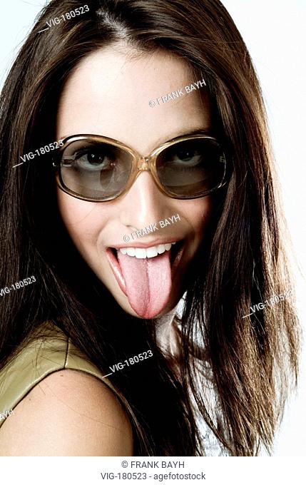 Darkhaired woman with sunglasses stretching out her tongue, portrait.  - STUTTGART, GERMANY, 13/06/2004