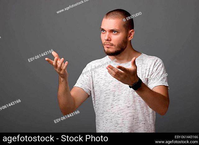portrait of angry screaming young man on gray background