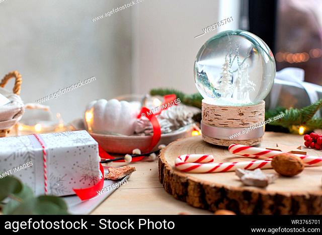Christmas decorations, a snow globe and presents and star shaped biscuits