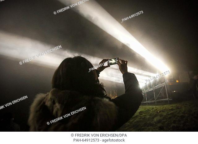 A woman takes a photograph as she watches a light installation on Jakobsberg hill in Ockenheim, Germany, 09 January 2016