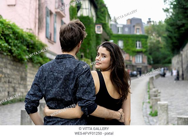 France, Paris, young couple in an alley in the district Montmartre