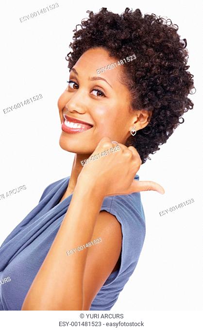 Portrait of smiling young woman pointing at back side with her thumb on white background
