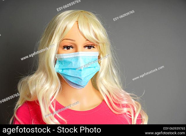 a shop window mannequin or display dummy head wearing protective face mask as shopping hygiene concept
