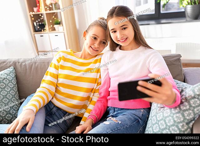 happy girls taking selfie with smartphone at home