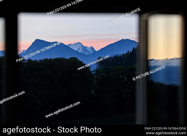 20 September 2023, Switzerland, Bern: A panorama of the Swiss mountains can be seen from a window at sunrise. Photo: Jan Woitas/dpa