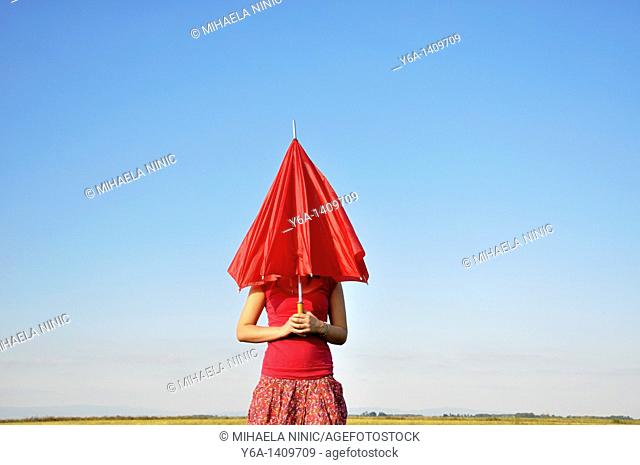 Young woman holding red umbrella