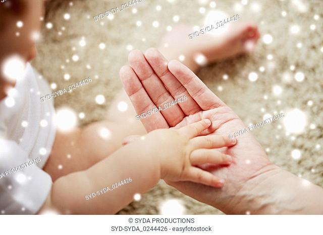 close up of little baby and mother hands