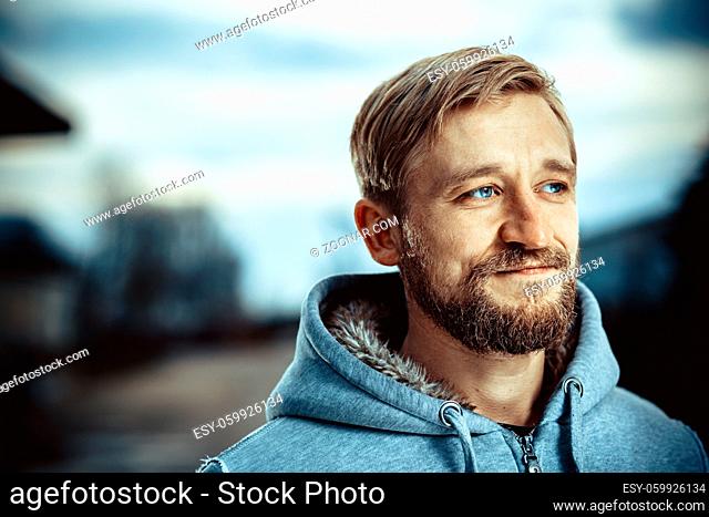 Young man with a beard and mustache outdoor portrait