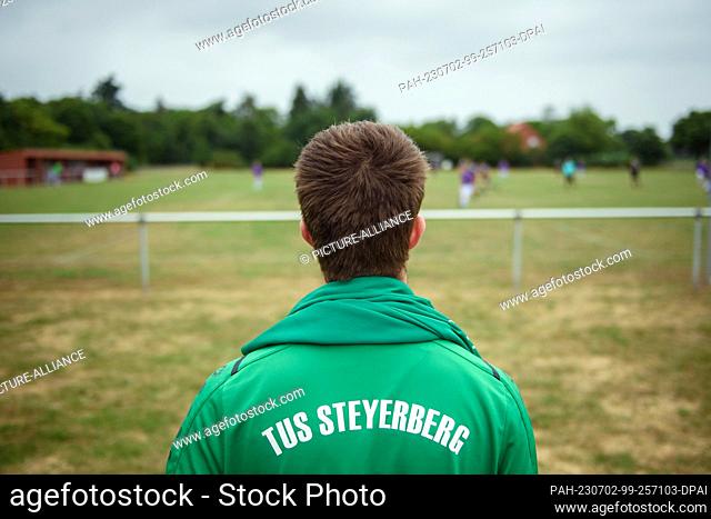 PRODUCTION - 01 July 2023, Lower Saxony, Deblinghausen: An amateur soccer player from TuS Steyerberg stands on the edge of the local soccer field in...