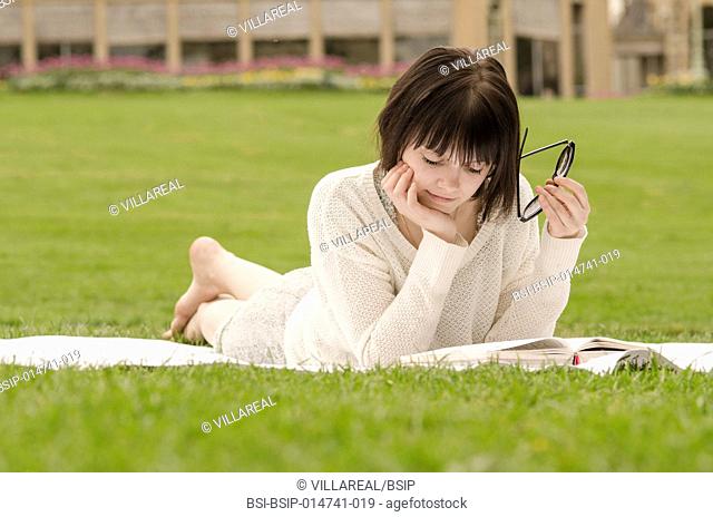 Young woman reading a book in a park