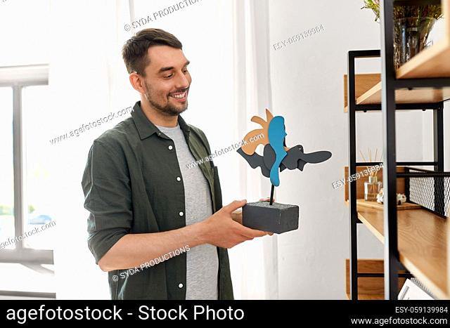 man decorating home with art in frame