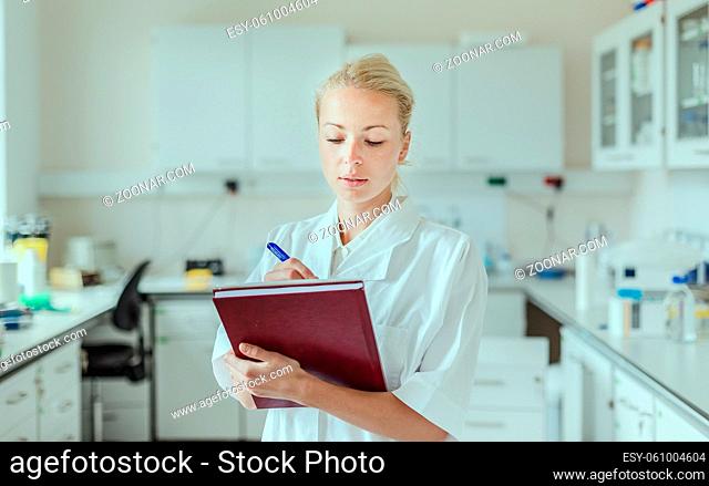 Portrait of young, confident female health care professional taking notes during inventory in scientific laboratory or medical doctors office