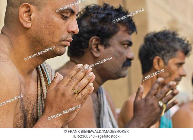 Praying men performing a ritual for the soul of a deceased person, at the ghats of Varanasi, India, Asia