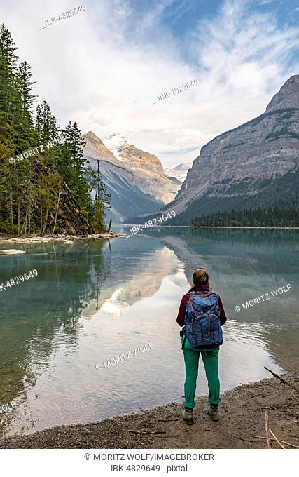 Female hiker overlooks Kinney Lake, snow-capped mountains at the back, Whitehorn Mountain, British Columbia, Canada