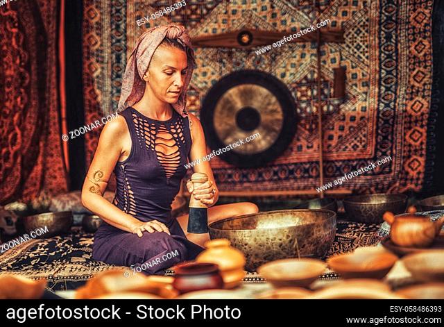Spiritual girl immersed in meditative sounds of tibetian bowl