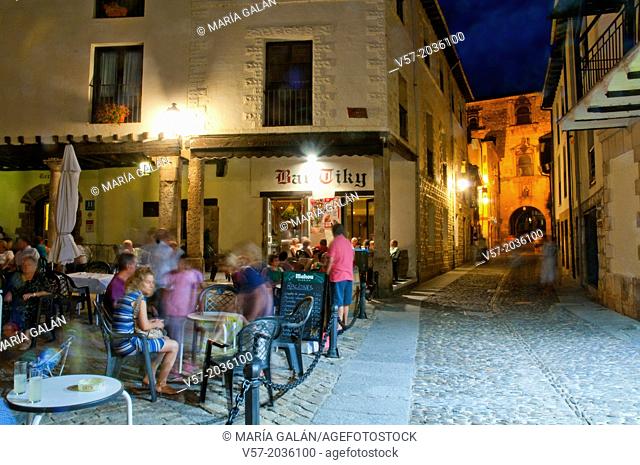 People sitting on terraces, night view. Doña Urraca Square, Covarrubias, Burgos province, Castilla Leon, Spain