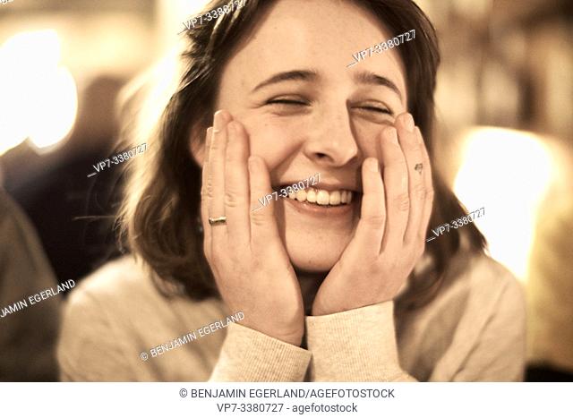 headshot of happy woman indoors in restaurant