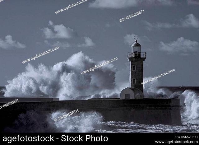 Stormy big waves crashing against old lighthouse. Used infrared filter