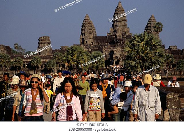 Tourists on stone causeway leading to temple complex. Many Cambodians visiting during Chinese New Year