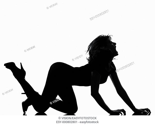 full length silhouette in shadow of a young woman crouching roar in studio on white background isolated