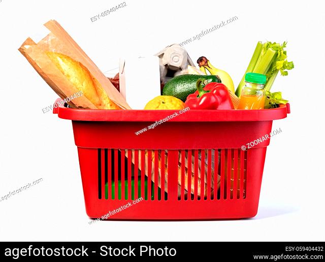 Plastic shopping basket with of grocery products isolated on white
