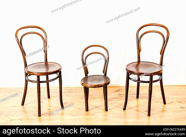two large and one childs chair in an empty room UK