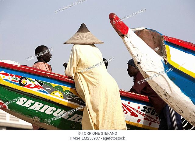 Senegal, Thies Region, Kayar, the beach and fishing harbour, fishermen among painted dugout canoes